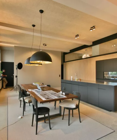 Moderne schwarze Küche und schlichter Holztisch, dunkle Hängeleuchten